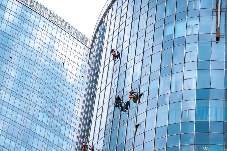 Several workers washing windows in the office building